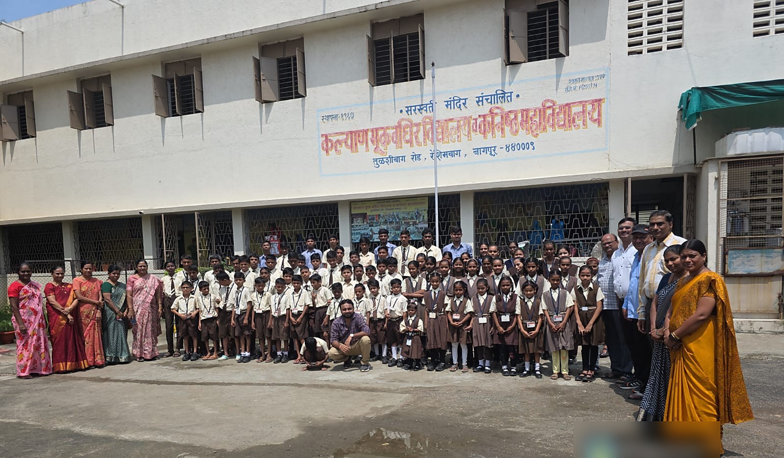 Students and Staff with the School Building